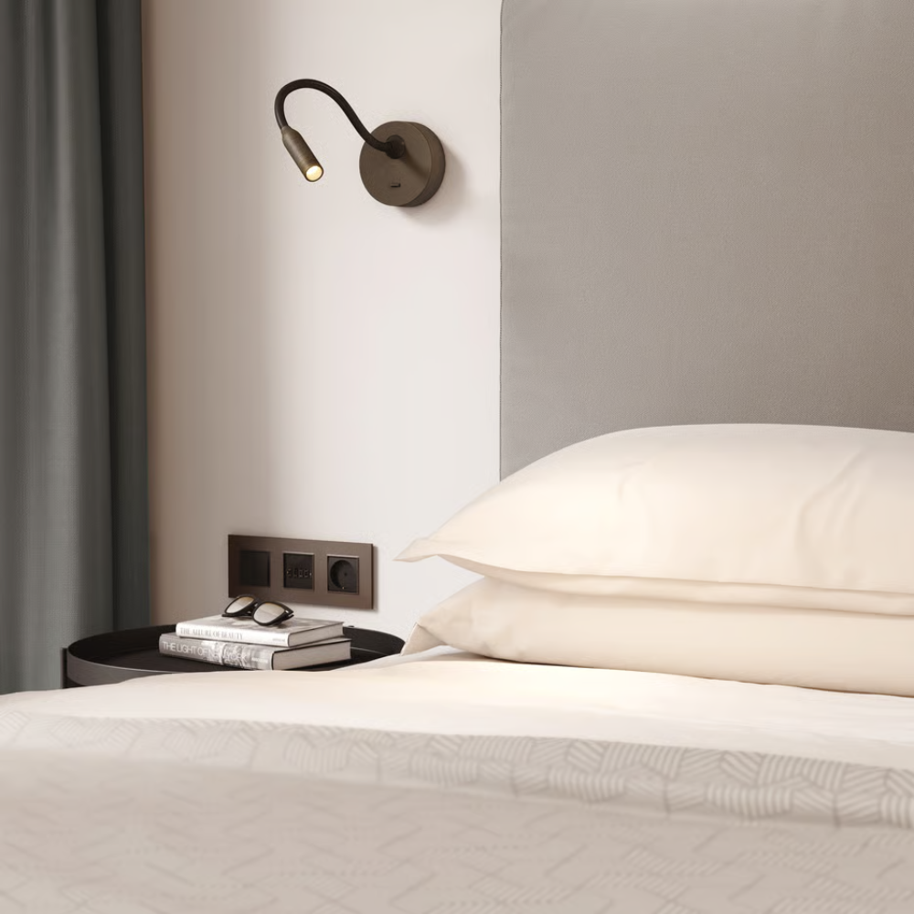 The bronze Lucca Surface Wall Sconce from Astro Lighting in a primary bedroom.