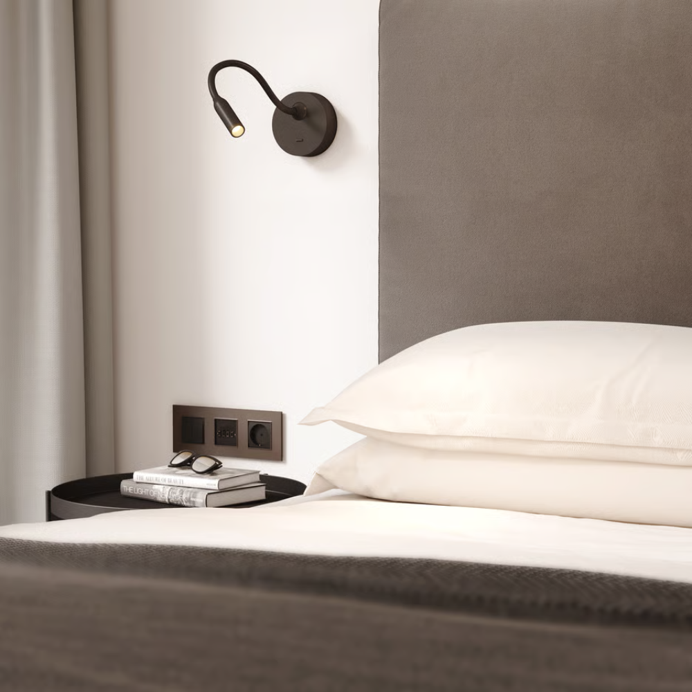 The matte black Lucca Surface Wall Sconce from Astro Lighting in a guest bedroom.