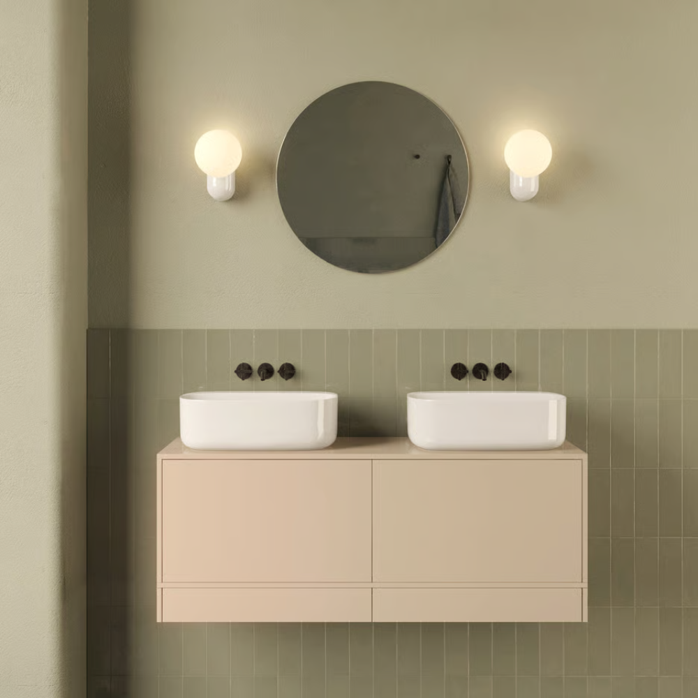 The Lyra Wall Sconce from Astro Lighting in a bathroom with a dual sink.