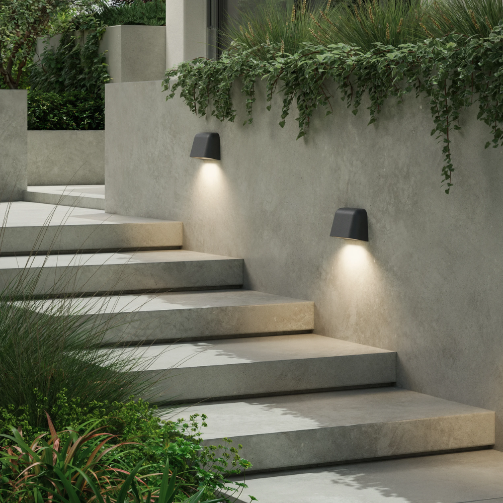 The Mast Twin Coastal Outdoor Wall Sconce by Astro Lighting in charcoal concrete installed outside on a wall in a stairway during the day.