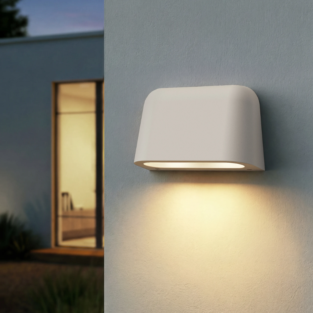 The Mast Twin Coastal Outdoor Wall Sconce by Astro Lighting in white concrete installed outside at night.