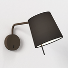 The bronze Mitsu Swing Arm Wall Sconce from Astro Lighting with the black shade in a family room.