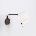 The bronze Mitsu Swing Arm Wall Sconce from Astro Lighting with the white shade in a living space.