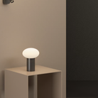 The Zeppo Portable Lamp from Astro Lighting in matt black on a side table.