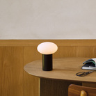 The Zeppo Portable Lamp from Astro Lighting in matt black in a workspace.