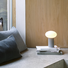 The Zeppo Portable Lamp from Astro Lighting in pebble grey in a living room.