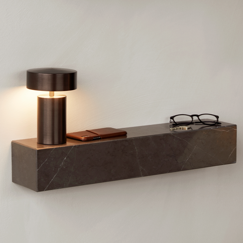 The Column Portable Table Lamp from Audo Copenhagen in anodized aluminum in a hallway.