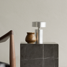 The Column Portable Table Lamp from Audo Copenhagen in brushed aluminum in a living room