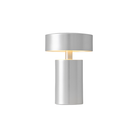The Column Portable Table Lamp from Audo Copenhagen in brushed aluminum with the light on.