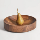 The Cusp Small Bowl from Blu Dot in walnut in a kitchen and dining setting.