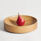 The Cusp Small Bowl from Blu Dot in white oak in a family room.