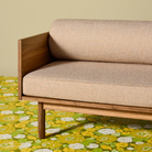 The Souvenir Sofa from Blu Dot with the irving copper stripe upholstery and white oak frame in a living room.