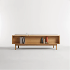 The Souvenir Sofa from Blu Dot with the landa stone upholstery and white oak frame from the back in a studio.