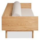 The Souvenir Sofa from Blu Dot with the landa stone upholstery and white oak frame from the side at an angle.