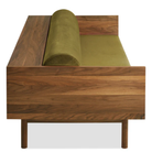 The Souvenir Sofa from Blu Dot with the loden green velvet upholstery and walnut frame from the side at an angle.