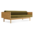 The Souvenir Sofa from Blu Dot with the loden green velvet upholstery and white oak frame from an angle.