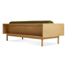 The Souvenir Sofa from Blu Dot with the loden green velvet upholstery and white oak frame from the back at an angle.