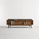 The Souvenir Sofa from Blu Dot with the storm velvet upholstery and walnut frame from the back in a studio.