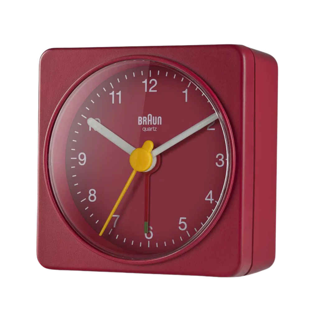 The red BC02 Travel Alarm Clock by Braun from an angle.