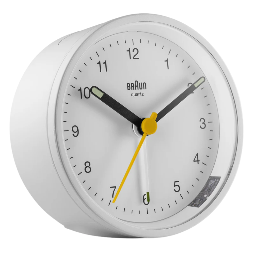 The white BC12 Round Alarm Clock by Braun from a side angle.