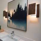 The Vesper Wall Sconce from Cerno in dark stained walnut in a bathroom.