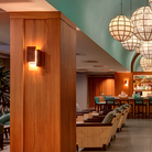 The Vesper Wall Sconce from Cerno in oiled walnut in a hotel.