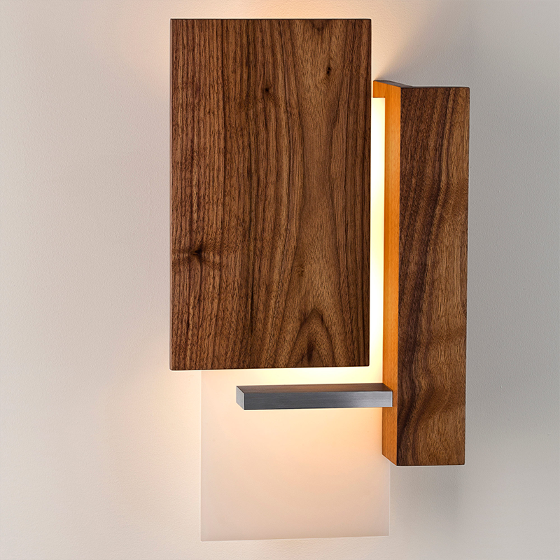 The Vesper Wall Sconce from Cerno in oiled walnut in a primary bedroom.