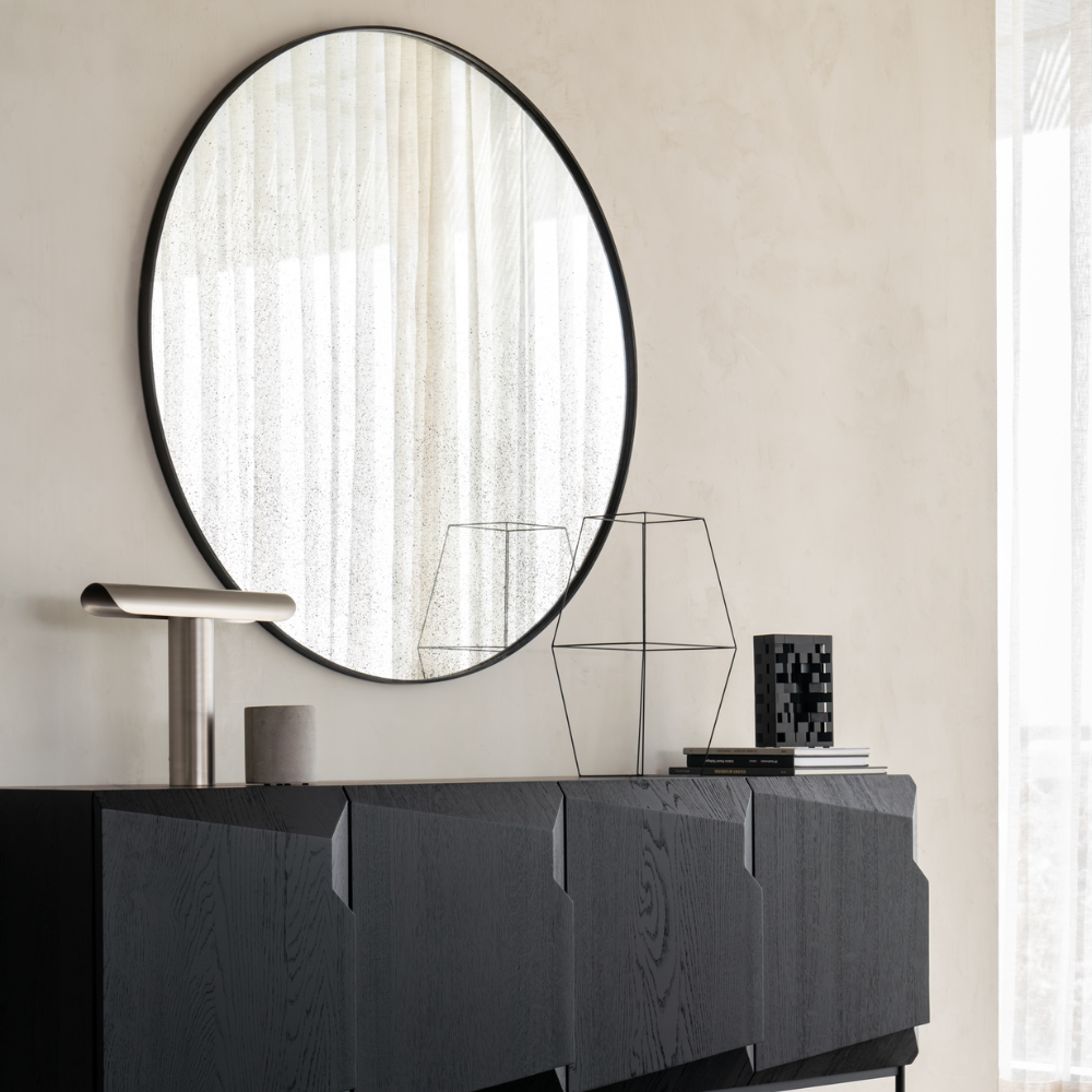 Aged Wall Mirror Round in Clear by Ethnicraft over a sideboard.