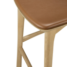 The Bok Upholstered Counter Stool from Ethnicraft is in leg and leather detail.
