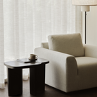 The Brutalist Rectangular Side Table by Ethnicraft is styled in a living room with a coffee cup on top.