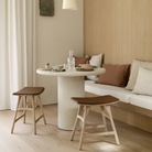 The 35.5-inch Elements Round Dining Table from Ethnicraft is in a living room.