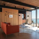 The black 265 Wall Lamp from Flos in a living room with a beach view.