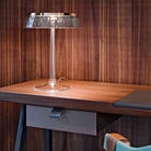 The Bon Jour Table Lamp from Flos in copper with fumee crown in a dining room.