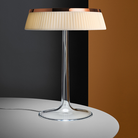 The Bon Jour Table Lamp from Flos in copper with plisse cloth crown in a living room.
