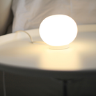 The Mini Glo-Ball Table Lamp from Flos in a workspace.