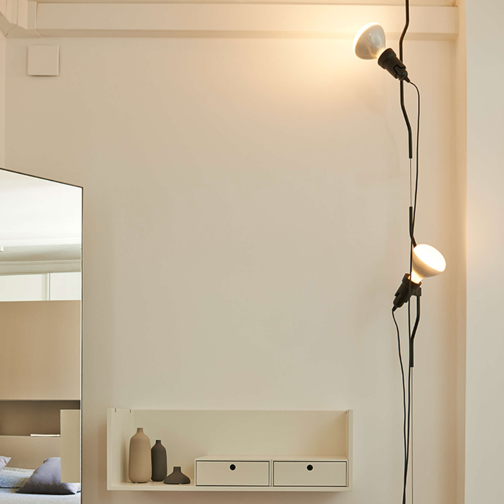 The Parentesi Lamp from Flos in Black in a white room.