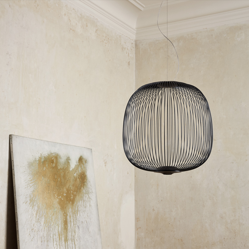 The Spokes 2 Pendant from Foscarini in large matte black hangs in a dining space.