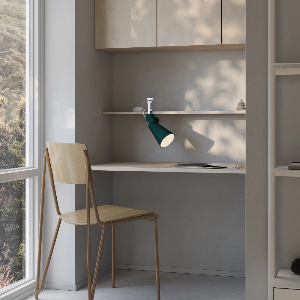 The forest Aim Clamp Light from Gantri with the white clamp in a living room.