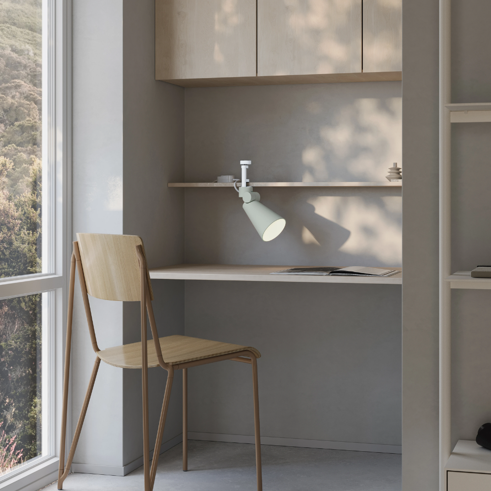 The meadow Aim Clamp Light from Gantri with the white clamp in a living room.