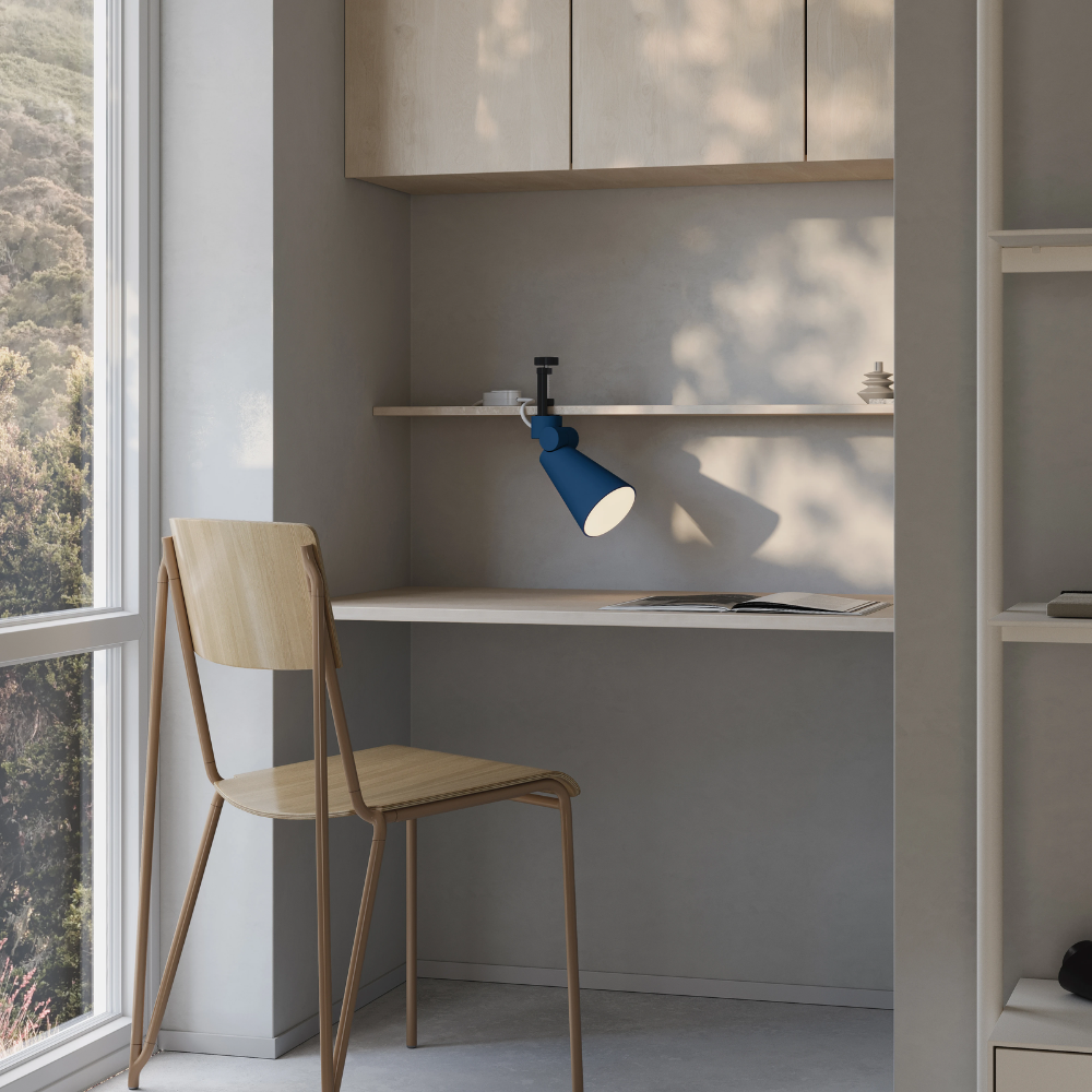 The midnight Aim Clamp Light from Gantri with the black clamp in a home office.