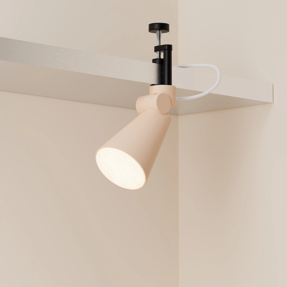 The peach Aim Clamp Light from Gantri with the black clamp.
