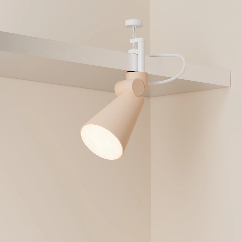 The peach Aim Clamp Light from Gantri with the white clamp.