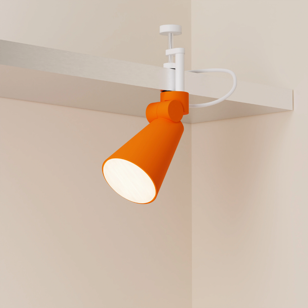 The persimmon Aim Clamp Light from Gantri with the white clamp.