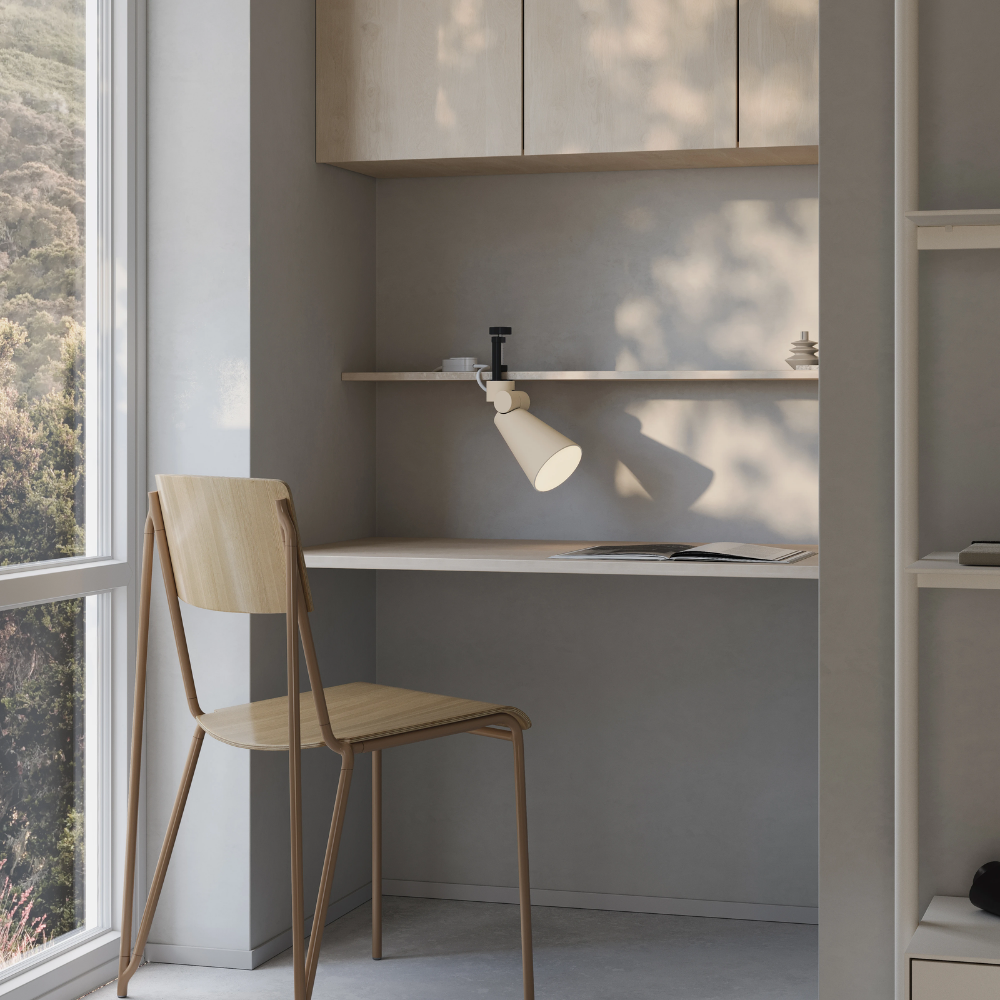 The sand Aim Clamp Light from Gantri with the black clamp in home office.