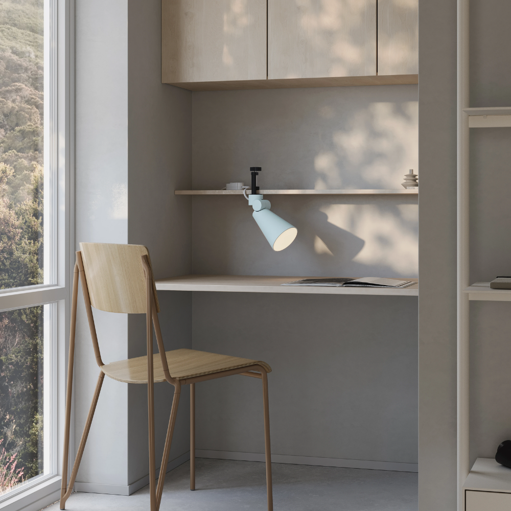 The sky Aim Clamp Light from Gantri with the black clamp in a home office.