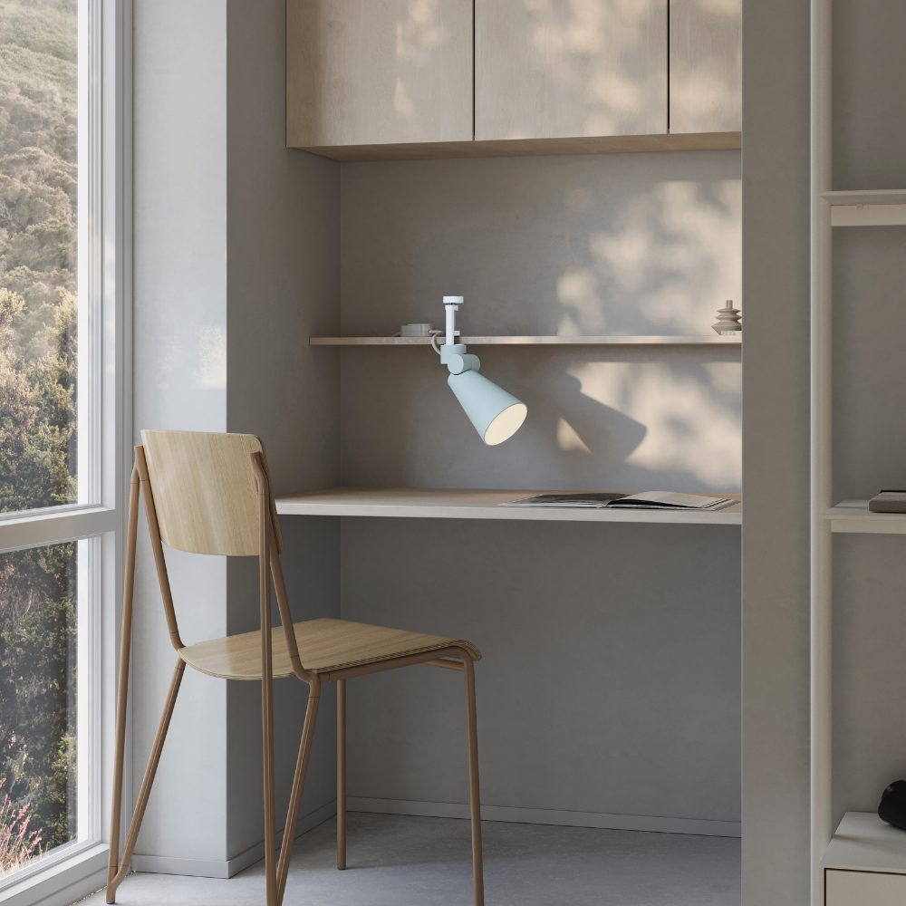 The sky Aim Clamp Light from Gantri with the white clamp in a living room.