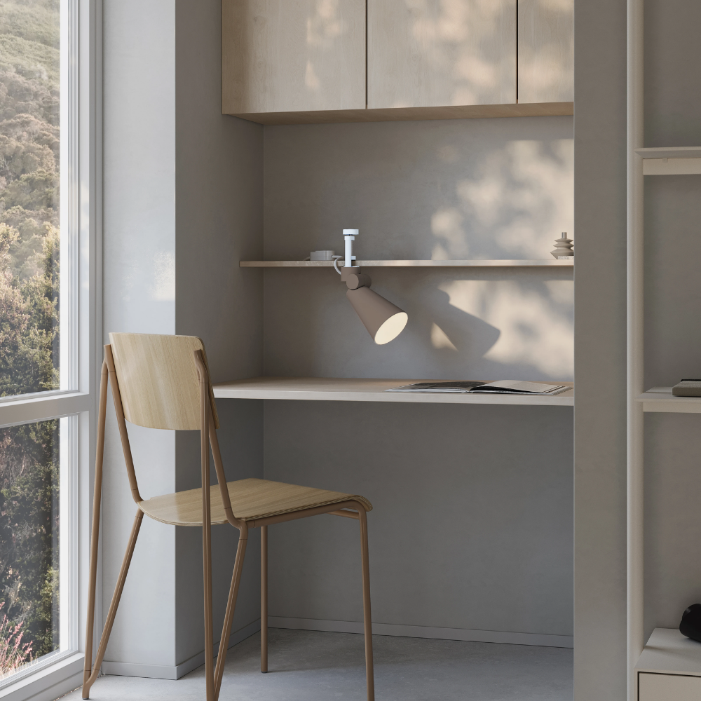 The smoke Aim Clamp Light from Gantri with the white clamp in a living room.
