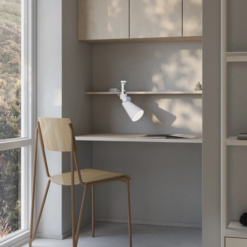The snow Aim Clamp Light from Gantri with the white clamp in a living room.