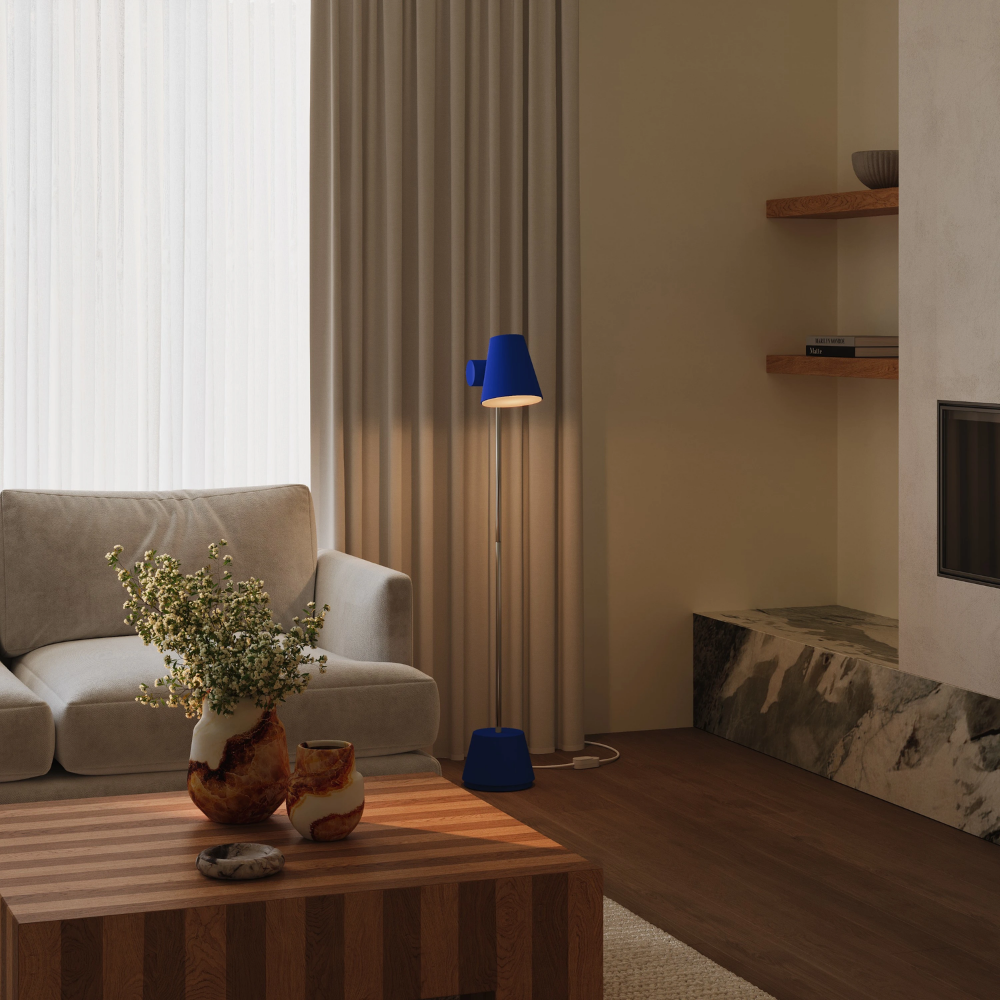 The cobalt Aim Floor Light from Gantri with the chrome rod option in  a lounge space.