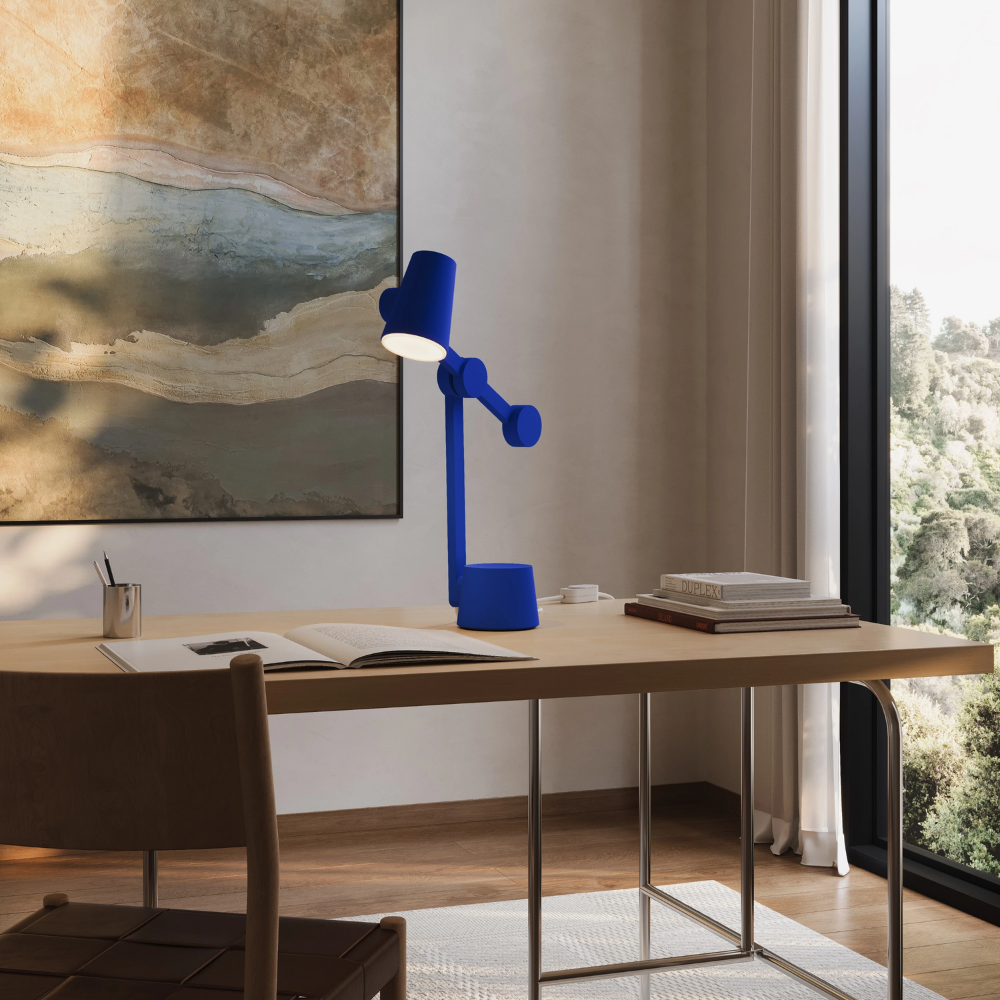 The cobalt Aim Task Light from Gantri in a home office.